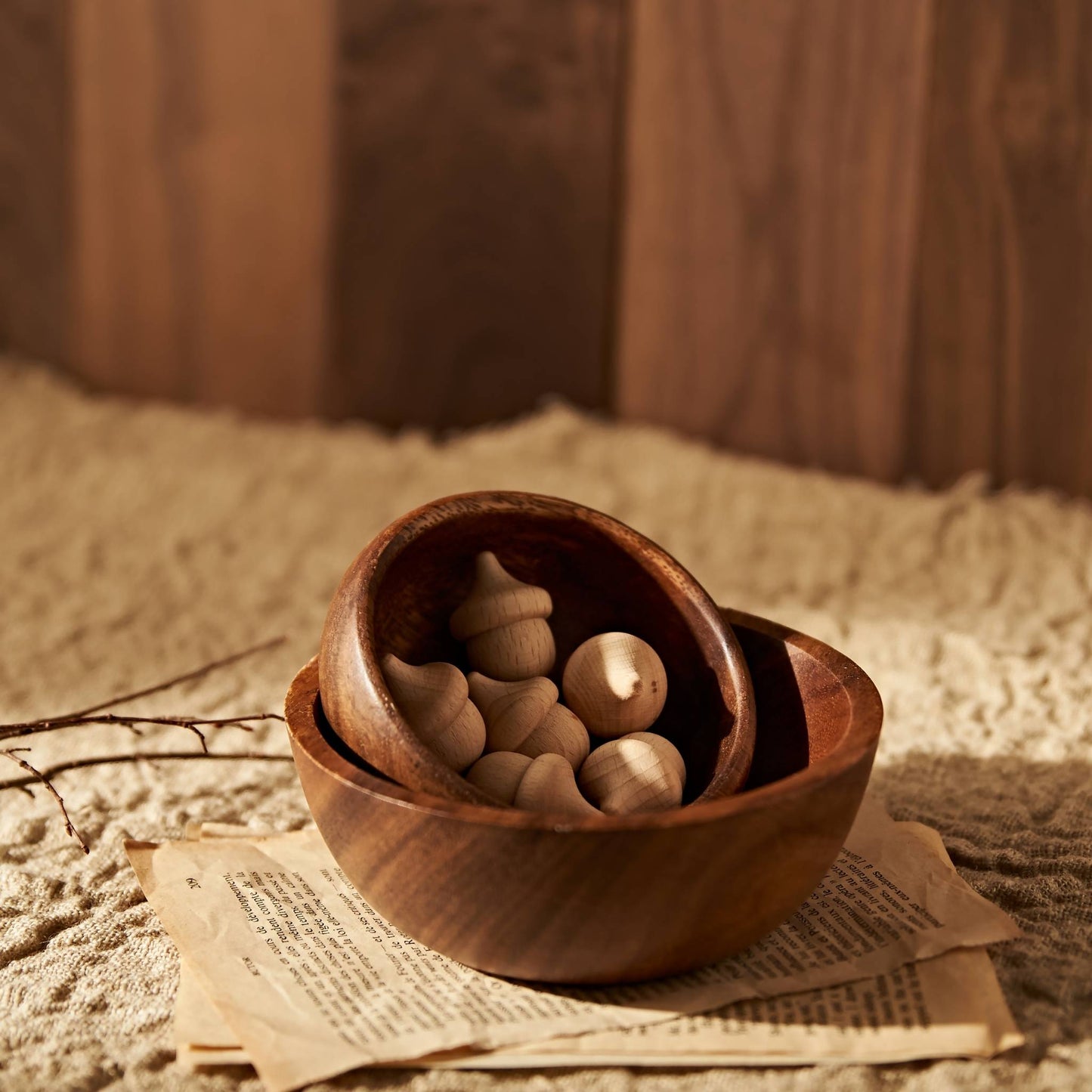 우드 트레이 위 원형 원목 볼에 수북하게 담긴 도토리 브리즈볼이 보이는 내추럴 인테리어 연출 사진