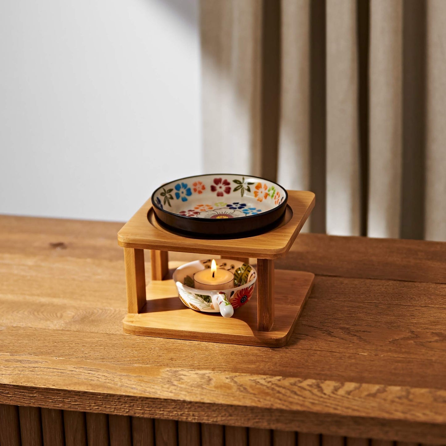  우드 스탠드 오일버너와 플라워 패턴 세라믹 볼, 아래 불이 켜진 티라이트 캔들이 켜진 연출사진
