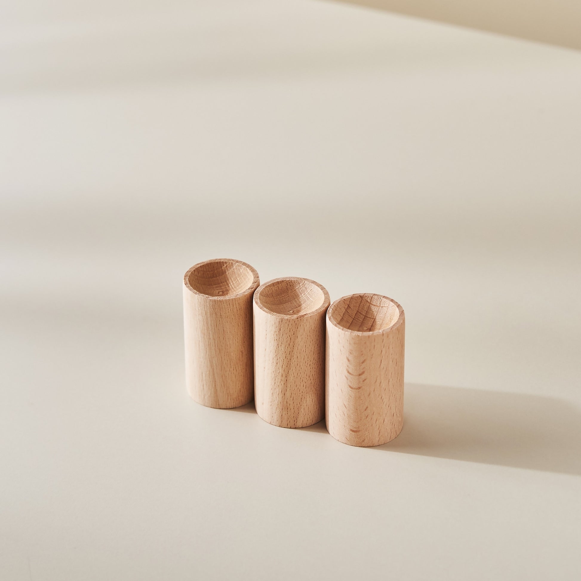 크림색 배경 위에 나란히 세워진 너도밤나무 원목 실린더 형태의 자연 발향 우드 디퓨저 세 개가 보이는 메인 제품 사진